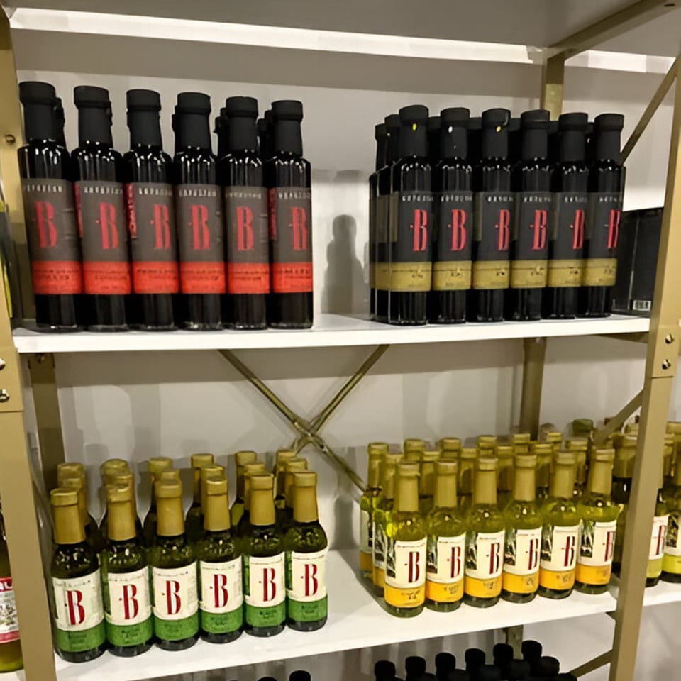 Shelves filled with various bottles of olive oil and balsamic vinegar from Cafe POM.